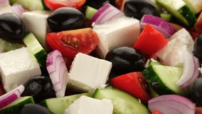 pouring olive oil on Greece salad with tomatoes, cucumbers, olive, onion and feta cheese close up. rotating