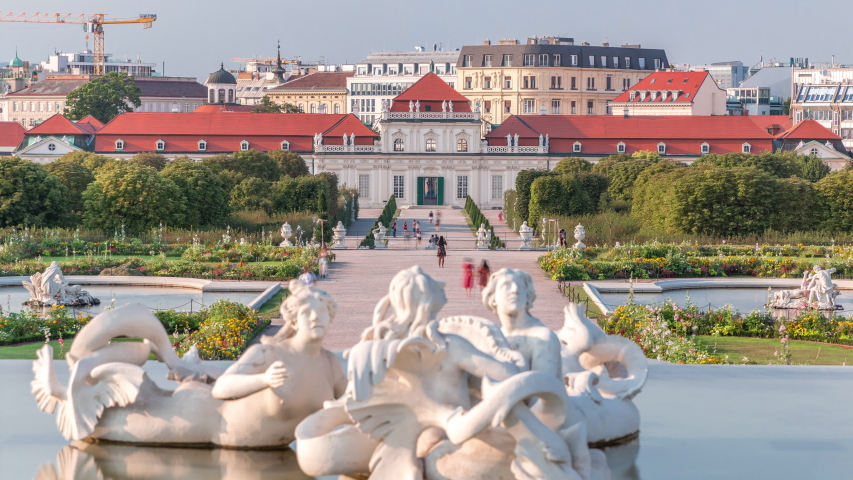 Belvedere palace with beautiful floral garden and fountain timelapse, Vienna Austria. Blue sky with clouds on sunny day. Green lawn and historic buildings