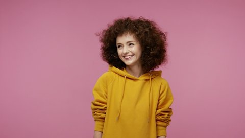 Happy joyful  young woman afro hairstyle in hoodie laughing out loud after hearing ridiculous anecdote, funny joke, feeling carefree amused, positive lifestyle. indoor isolated on pink background