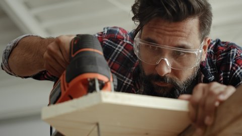 Video of carpenter sawing wood with an electric jigsaw. Shot with RED helium camera in 8K