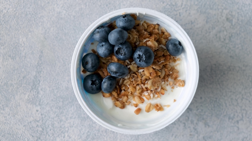 Yogurt with granola and blueberries in a jar. Female eating healthy breakfast fitness yoga food, sustainable eating Royalty-Free Stock Footage #1057556542