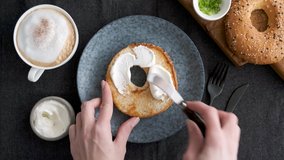 Spreading cream cheese on bagel. Female chef prepare toasted bread sandwich with cream cheese for breakfast, top view - Powered by Shutterstock - Get 15% off with code: PIKWIZARD15