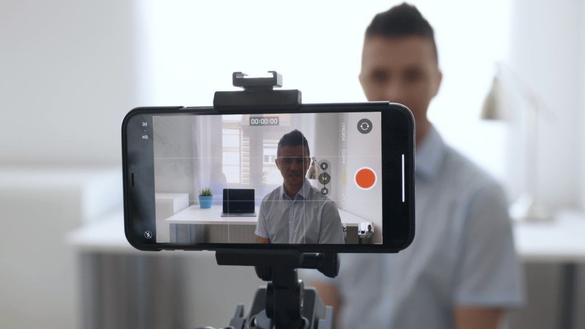 4K Medium Of Man Starting To Record A Video On Smartphone In Bright Office | Shutterstock HD Video #1057559521