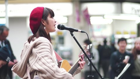 Kyoto / Japan - 03 23 2019: Japanese Girl Guitarist Singersong Writer Busking Happily in Kawaramachi