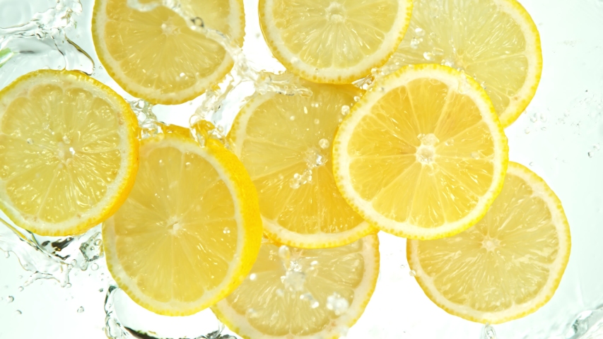Super Slow Motion Shot of Lemon Slices Falling into Water on White Background at 1000fps. Royalty-Free Stock Footage #1057568251
