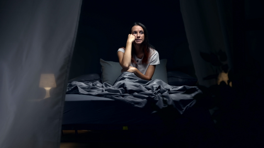 Sad woman suffering from insomnia and heat, she is sitting in bed and thinking Royalty-Free Stock Footage #1057569145