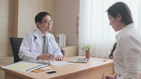 asian female patients consulting with Experting Asian male medical doctor in medical office hospital room