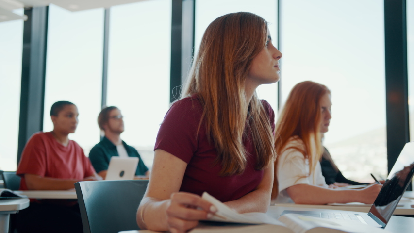 Female student sitting at her desk and paying attention to the lecture. High school classroom with students studying.
 Royalty-Free Stock Footage #1057573723