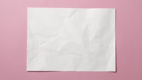 White crumpled paper texture on pink background. Stop motion animation.  Seamless loop. You can combine this clip with paper balls and icons to make a message or tale.