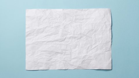 White crumpled paper texture on light blue background. Stop motion animation.  You can combine this clip with paper balls and icons to make a message or tale.