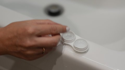 Removes contact lenses for vision correction and places them in a contact lens container