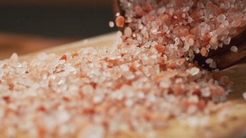 Very Close-up.Pink himalayan rock salt on a delicious background and wood floor passes in front of the camera in slow motion.Macro,Phantom Camera, 900 fps video.