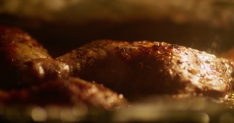 Close-up of baking hot grill chicken legs in the oven. Roasted chicken meat close-up, 4k footage.
