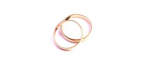 Wedding Golden Rings on white background isolated falling on isolated surface. Beautiful footage with copy space in High quality FullHD.