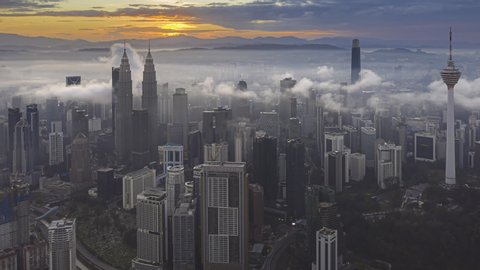Kuala Lumpur Aerial Time lapse: Malaysia beautiful view during dawn overlooking the city skyline in Federal Territory, Malaysia from afar with sun rays. Zoom out motion timelapse. Prores 4KUHD