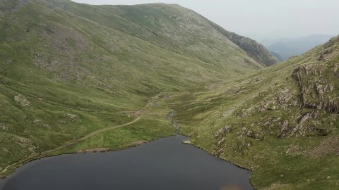Aerial drone view flying along a narrow mountain pass in the Lake District (Sty Head Pass)