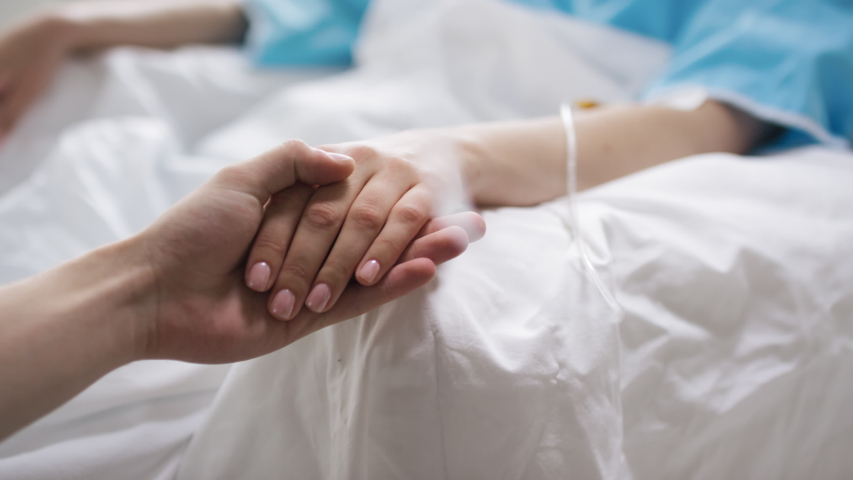 Close up shot of unrecognizable man holding hand of sick woman lying in hospital bed Royalty-Free Stock Footage #1057599388