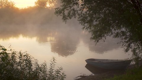 Early sunrise morning mist on peaceful calm river in countryside