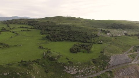 Aerial footage of scenic Great Orme, beautiful mountain cliff edge in coastal town Llandudno, North Wales near Snowdonia National Park. Mountain and Ocean View.  