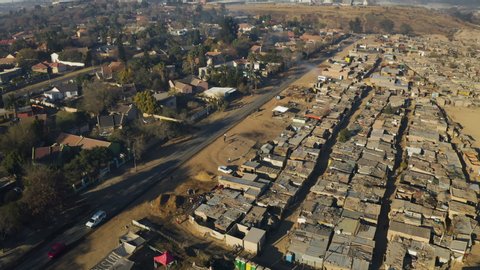 Poverty.Inequality.Aerial fly over view of an informal settlement Kya Sands squatter camp right next to middle class suburban housing, Gauteng Province, South Africa