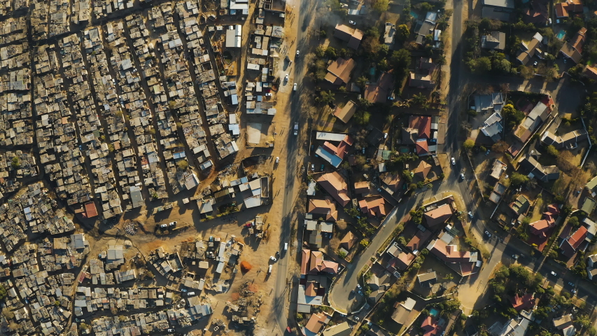 Inequality.Poverty.Aerial straight down view of an informal settlement Kya Sands squatter camp right next to middle class suburban housing, Gauteng Province, South Africa | Shutterstock HD Video #1057609936