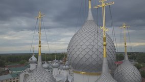 Five grey domes with golden crosses against cloudy rainy skies. Aerial low angle view 