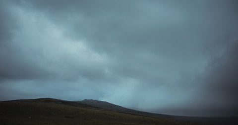 Time lapse of dark storm clouds over gloomy moorland landacape