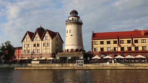 KALININGRAD, RUSSIA - JULY 29, 2020: Fish village district with a lighthouse on the bank of the Staraya Pregolya river in the rays of the setting sun. Kaliningrad, Russia
