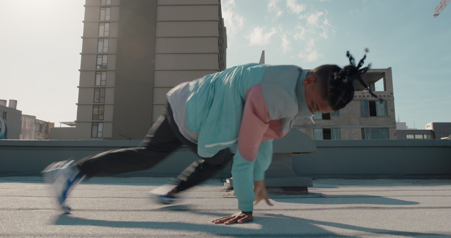 Dancing man breakdancing on roof top hip hop dancer practicing dance routine performing freestyle moves in city | Shutterstock HD Video #1057631677