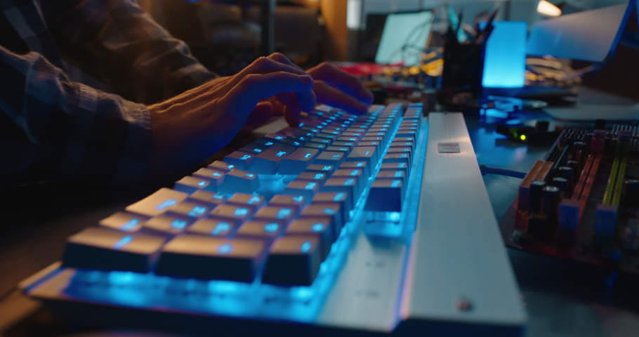 computer hands typing on keyboard browsing online gaming late at night using keyboard with blue backlight Royalty-Free Stock Footage #1057632217