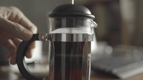 Making French press coffee on the working table at home. Pressing the plunger down. - Powered by Shutterstock - Get 15% off with code: PIKWIZARD15