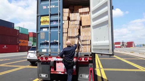 CIRCA 2020 Customs and Border Patrol Officers at the Port of New York/Newark inspect a shipment of boxes from China.