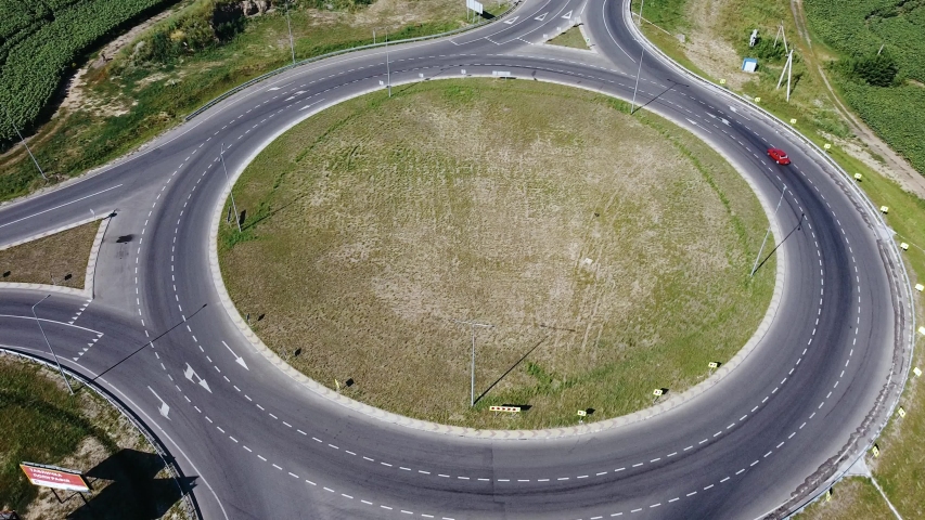 Aerial top view of cars and trucks driving along the ring road on a sunny day