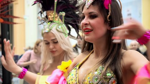 MOSCOW, RUSSIA- FEBRUARY 29, 2020: Beautiful girls dancers dance samba. Brazilian carnival atmosphere, pretty cabaret diva in a carnival costume of colored fabrics, rhinestones and feathers performs