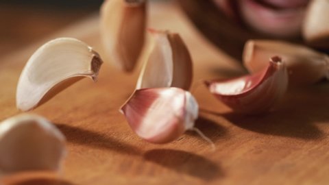 Macro,Phantom Camera,Very Close-up, 900 fps video.The garlic passes in front of the camera in slow motion on a wooden background. 