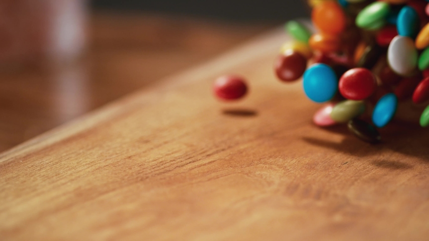 Very Close-up.Multi-colored candy balls on a delicious background and a tree backdrop pass in front of the camera in slow motion. Macro,Phantom Camera, 900 fps video. Royalty-Free Stock Footage #1057638232
