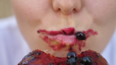 Close up of hungry mouth eating cake with berry sauce. Enjoying the food