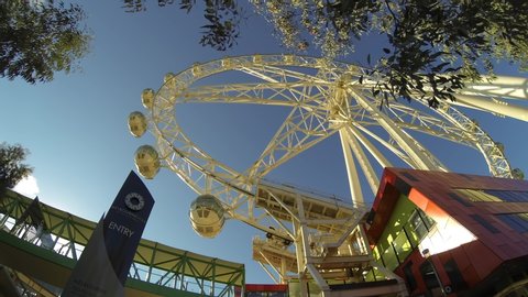 Melbourne , Victoria / Australia - 08 12 2020: Melbourne Star Docklands Melbourne Ferris Wheel time-lapse side angle looking up to blue sky