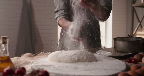 Experienced mature chef applying flour on hands while making traditional bread at bakery. Old man baking at home, enjoying hobby - closeup shot 4k footage