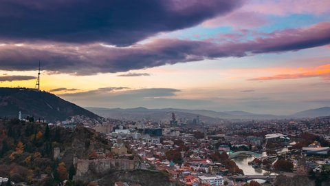 Tbilisi, Georgia. Top View Of Famous Landmarks In Night Illuminations. Georgian Capital Skyline Cityscape. City During Sunset And Night Illuminations. Day To Night Transition.