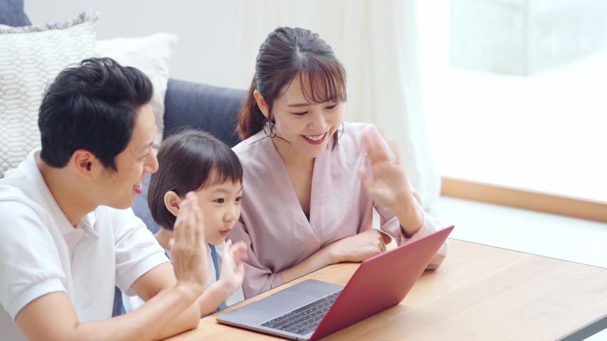 Asian family using a laptop pc in modern interior. Videophone. Royalty-Free Stock Footage #1057658305