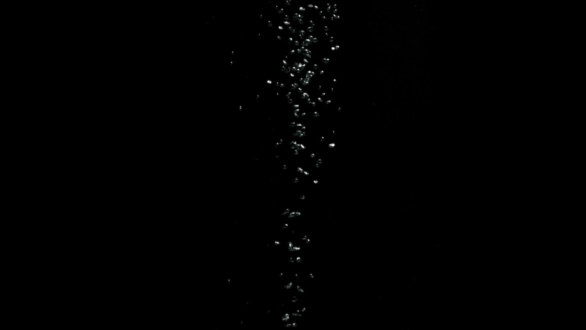 A stream of small bubbles moving from the bottom to the top over a black background from the Submerge collection - Water VFX Video Element. | Shutterstock HD Video #1057663360