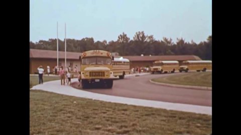 CIRCA 1970s - An elementary school teachers stresses the importance to her students of going straight home after being dropped off by the school bus.