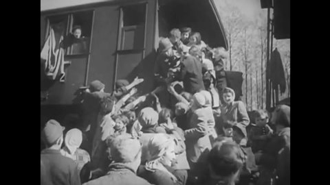 CIRCA 1940s - Weary rescued WW II concentration camp survivors climb aboard railroad cars, Germany in 1946, and begin their travel back.