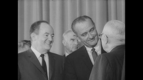 CIRCA 1965 - Former President Truman, the First Lady, and Vice President Humphrey look on as LBJ signs the Medicare Bill into law.