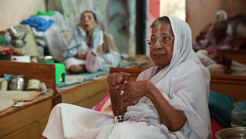 VRINDAVAN, INDIA - JUNE 13, 2015: Old Indian women in a white sari widows s...