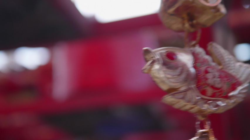 The good lucky fish hanging mobile. The Chinese symbol of lucky life or the feng shui symbol in the Chinese shrine or Chinese temple. The meaning of the words on the fish are good luck or happiness.