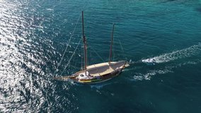 Aerial drone tracking video of classic wooden sail boat cruising Aegean open ocean sea, Greece