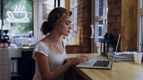 Young freelancer woman working by laptop PC in a coffee shop
