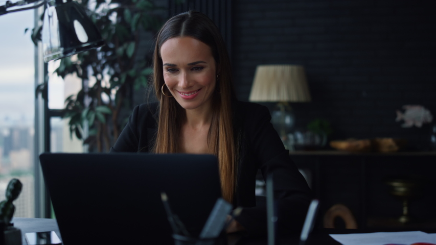 Smiling businesswoman using laptop computer for work in office. Positive female professional reading document at laptop screen indoors. Portrait of happy business woman typing on laptop keyboard | Shutterstock HD Video #1057689463